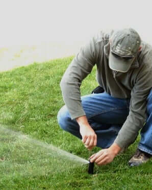 man fixing irrigation system - High Prairie Landscape Group